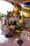 Woman praying in wat to reclining Buddha  surrounded by flowers