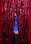 Woman Preforming Burlesque on Stage. Blue Corset Costume With Red Background