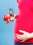 Woman in pregnant holding apple and glucometer with result sugar level, concept of diabetes during pregnancy