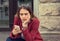 Woman preoccupied looking at her phone sitting near her house apartment building outdoors outside background