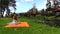 Woman prepare picnic place on orange plaid rug near river water