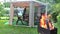 Woman prepare supper table in outdoor bower. Firewood burn