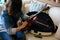 Woman prepare violin from violin case on sofa