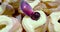 Woman prepares delicious cream desserts called zeppole of St. Joseph and use the spoon for insert black cherry with syrup on top