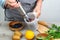 Woman prepares a healthy detox drink in a blender - a green smoothie with fresh fruits, blueberries, green spinach and kiwi