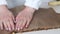 A woman prepares kozinak from nuts. Lay the toasted nuts on a non-stick mat, cover and smooth. Sunflower seeds, peanuts and