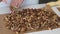 A woman prepares kozinak from nuts. Lay the toasted nuts on a non-stick mat. Sunflower seeds, peanuts and walnuts roasted in sugar