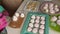 A woman prepares marshmallow cones. Ready-made sweets are laid out on trays. Close-up shot