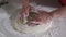 Woman prepares traditional ossetian pie with cheese and green onions on table