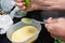 Woman preparing cheesecake in the kitchen with various ingredients