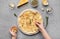 Woman preparing cheesy pizza and decorating it