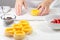 Woman preparing dessert, mini biscuit cups with strawberries and blueberries