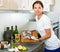 Woman preparing fresh codfish at kitchen