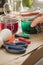 Woman preparing liquid green and red Easter cold colour color in glass in domestic kitchen next to orange, yellow, blue dye in