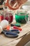 Woman preparing liquid green and red Easter cold colour color in glass in domestic kitchen next to orange, yellow, blue dye in