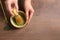 Woman preparing matcha tea at wooden table, top view. Space for text