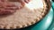 Woman preparing Ossetian meat pie in a frying pan, make cake decoration close up