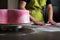 Woman preparing pink fondant for cake decorating, focus on the cake