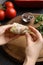 Woman preparing stuffed cabbage roll at table, closeup