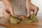 Woman preparing stuffed grape leaves on wooden board, closeup