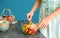 Woman preparing tasty salad with sliced peaches and arugula