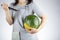 woman is preparing to stab a watermelon using a sharp kitchen knife.