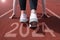 woman preparing to start on an athletics track engraved with the year 2024