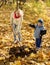 Woman with preschooler setting tree in autumn