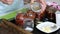 A woman preserves sun-dried tomatoes. Puts the ingredients in glass jars. The camera moves away on the slider. Close-up