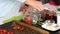 A woman preserves sun-dried tomatoes. Puts the ingredients in glass jars. The camera moves on a slider. Close-up