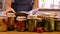 A woman is preserving vegetables in the kitchen. Selective focus.