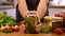 A woman is preserving vegetables in the kitchen. Selective focus.