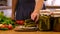 A woman is preserving vegetables in the kitchen. Selective focus.