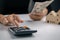 Woman presses a calculator and holding dollar bill to calculate the value during rental or purchase. Buying, Renting home,