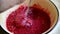 Woman presses raspberry to cook jam