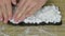 A woman presses rice on a nori leaf. Cooking sushi at home. Close-up shot