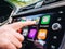 Woman pressing button on the Apple CarPlay of Maps GPS