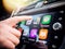 Woman pressing button on the Apple CarPlay of Maps GPS