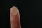 Woman pressing control glass of biometric fingerprint scanner on dark background, closeup.