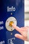 Woman pressing info button of assistance machine in train station