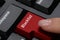 Woman pressing red button with word Blacklist on computer keyboard, closeup