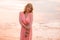 Woman in pretty dress at the beach during sunset