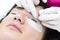 Woman on the procedure for eyelash extensions,