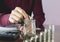 Woman process and drop coin into the glass with stack coins