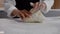 Woman Professionally Forms Dough on Floured Table.