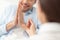 Woman proposing to her boyfriend in bedroom. Close up shot of female hand holding up proposal ring to her boyfriend who