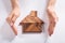 Woman Protecting House Made Of Wooden Tangram Puzzle