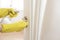 Woman in protective gloves disinfecting door handle while cleaning at home, close-up view on hands