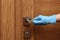 Woman in protective gloves opening door, closeup