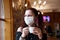 Woman in a protective mask drinking coffee in cafe